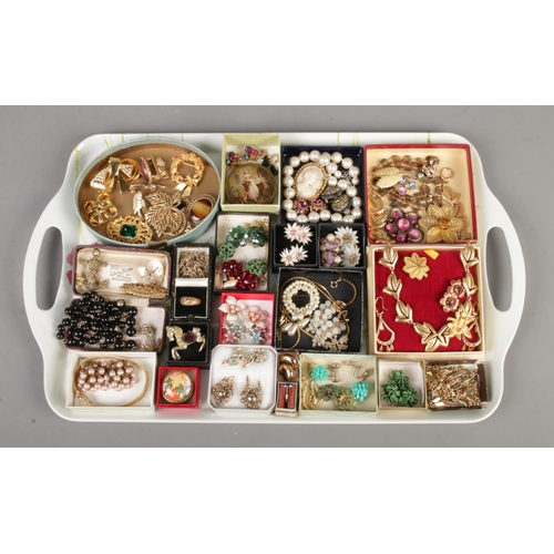 98 - A tray of vintage costume jewellery, including clip on earrings, brooches, pendants, and necklaces.