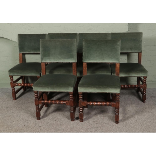 476 - A collection of six green velvet upholstered chairs featuring bobbin turned supports.