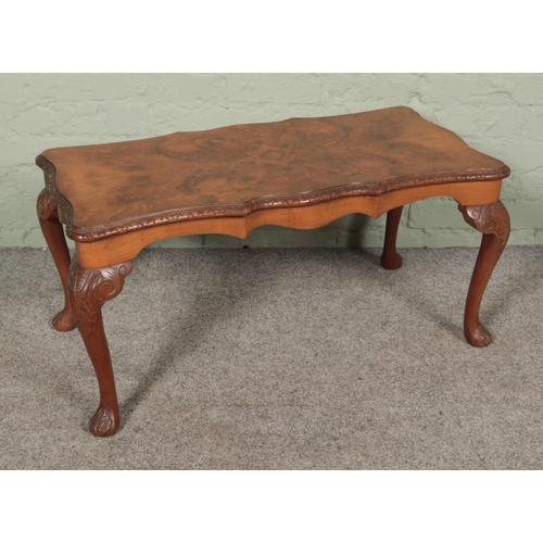 493 - A bur walnut coffee table featuring cabriole legs with carved scroll detail. Approx. dimensions 90cm... 