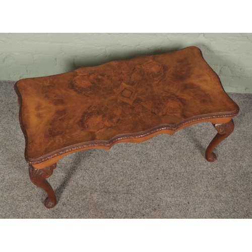 493 - A bur walnut coffee table featuring cabriole legs with carved scroll detail. Approx. dimensions 90cm... 