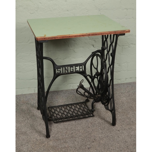 495 - A cast iron singer sewing machine base with wooden top