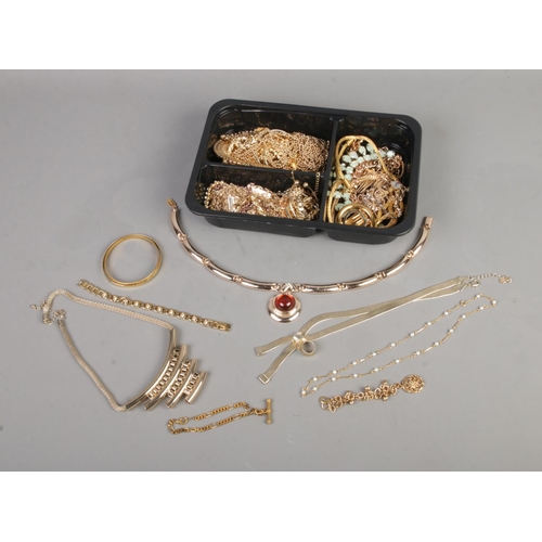 108 - A tray of yellow metal jewellery to include articulated fish charm, necklaces, bangles, etc.