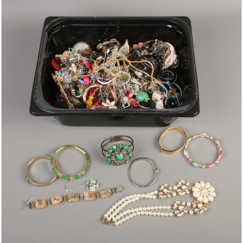 111 - A tub of assorted costume jewellery to include necklaces, bracelets, bangles, etc.