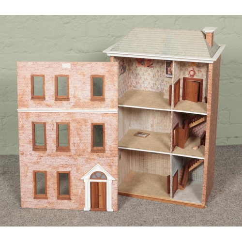 222 - A vintage three storey dolls house along with painted dolls crib.