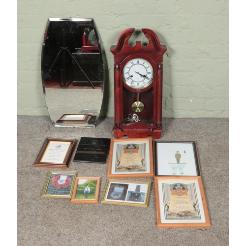 305 - A 31 Day wall clock along with a bevel edge wall mirror and collection of framed military pictures.