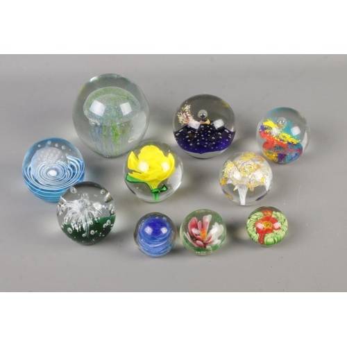 77 - A collection of ten glass paperweights to include Alum Bay Glass and Mdina examples.