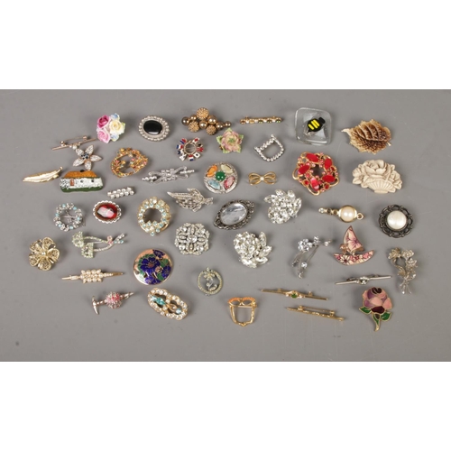 93 - A collection of over 40 costume jewellery brooches to include rose, flag, leaf and bumblebee example... 