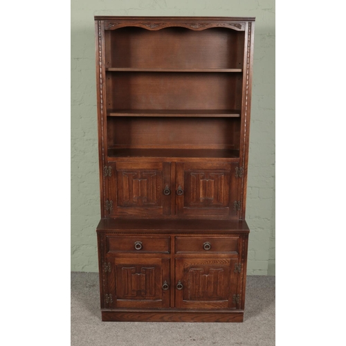 451 - A carved oak bookcase with lower cupboard featuring linen fold decoration. Approx. dimensions 95cm x... 