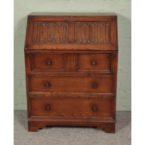 453 - An oak linen fold bureau featuring leather inset top. Approx. dimensions 77cm x 100cm x 44cm.