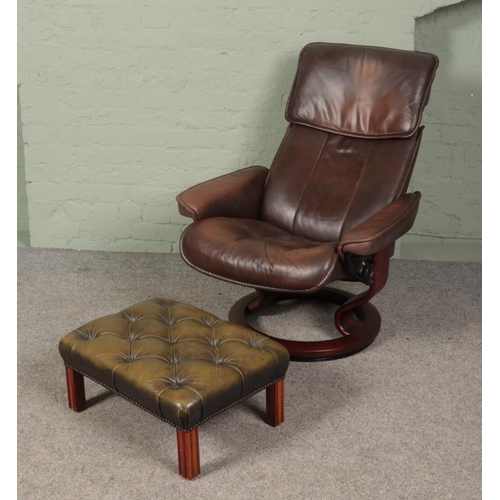 467 - An Ekornes Stressless brown leather reclining armchair along with a green leather buttoned footstool... 