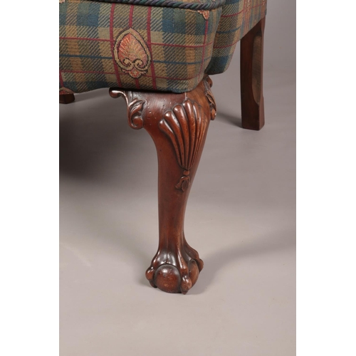 135 - An antique style wing back arm chair raised on carved mahogany ball and claw feet, along with a foot... 