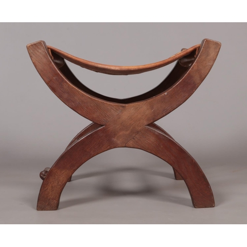 139 - Robert 'Mouseman' Thompson, an oak xframe stool with leather seat. Having carved mouse signature.