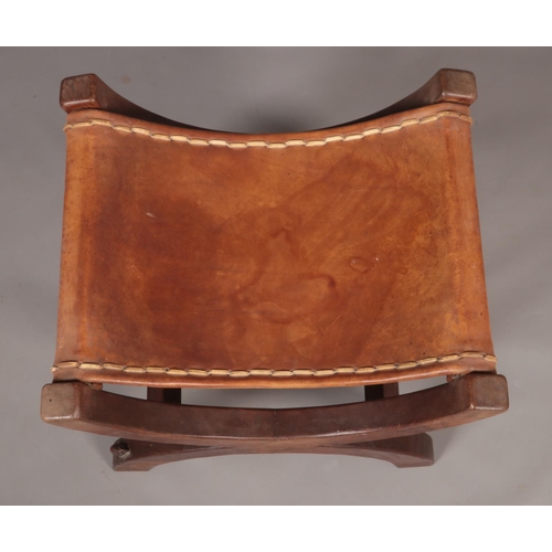 139 - Robert 'Mouseman' Thompson, an oak xframe stool with leather seat. Having carved mouse signature.