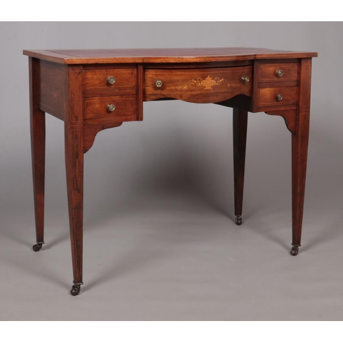 142 - An early 20th century writing desk with leather inset top and tapering supports.