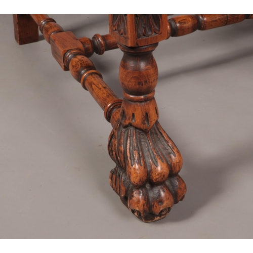 143 - A French style carved walnut throne chair raised on paw feet. Height of back 113cm.