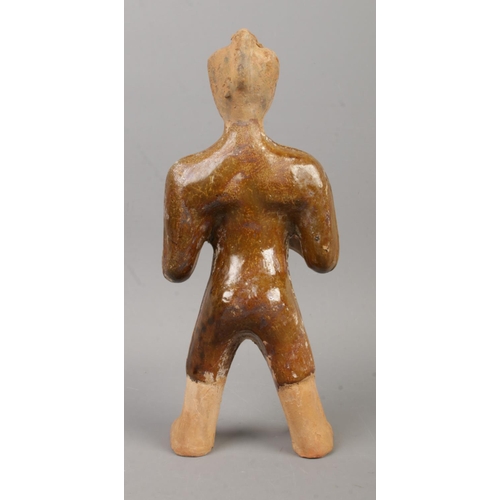 30 - A partially glazed Chinese terracotta tomb figure formed as a servant with outstretched arms. Purpor... 