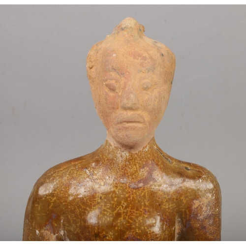 30 - A partially glazed Chinese terracotta tomb figure formed as a servant with outstretched arms. Purpor... 