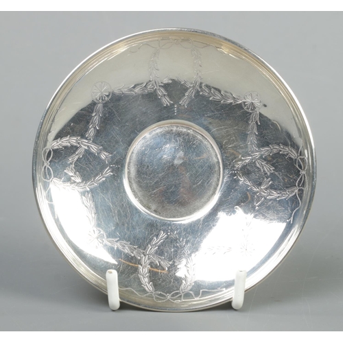 62 - An early 20th century silver cup and saucer with engraved swag and bow decoration. Assayed Chester 1... 