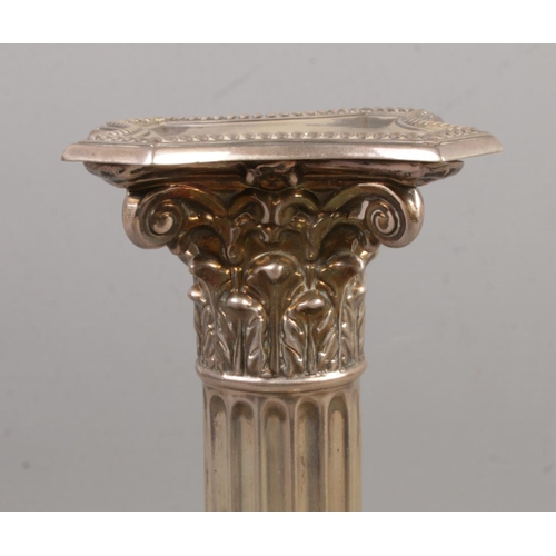 69 - A set of four Victorian silver candlesticks formed as Corinthian columns raised on stepped bases. As... 