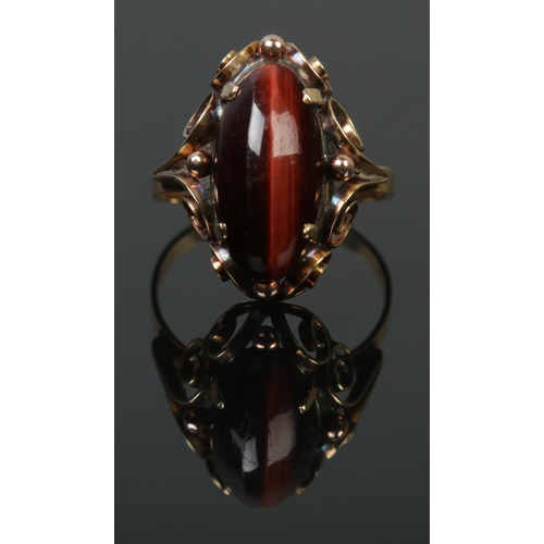 91 - A 14ct gold and tigers eye ring with scrollwork border. Size N. 3.3g.