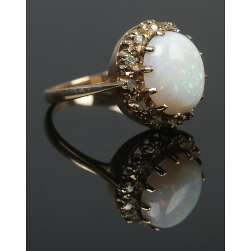 96 - A 9ct gold dress ring set with a large cabochon opal stone within a diamond halo surround. Hallmarks... 