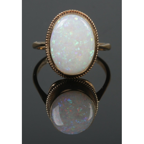 97 - A 9ct gold dress ring set with a large opal stone. Opal stone 1.7cm x 1.2cm. Size Q. 3.32g.