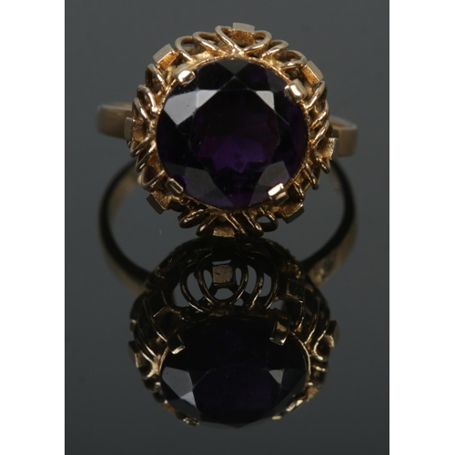 98 - A 9ct gold ring set with a large amethyst coloured stone. Size P 1/2. 4.42g.