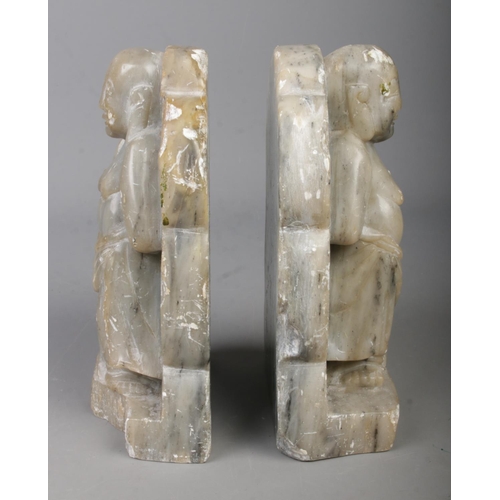 279 - A pair of soapstone bookends formed as mirrored buddhas.