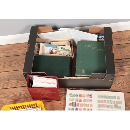 332 - A box of assorted stamps, first day covers and postcards to include Victorian Penny Red,  Royal Mail... 