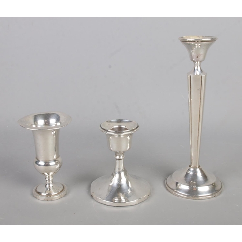 583 - Three silver weighted candlesticks featuring varying hallmarks to include S. Blanckensee & Son Ltd e... 