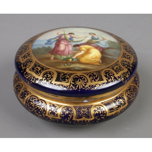 579 - A porcelain circular powder bowl with cover, hand painted with classical maidens, within a blue and ... 