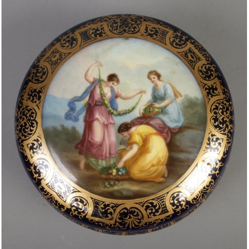 579 - A porcelain circular powder bowl with cover, hand painted with classical maidens, within a blue and ... 