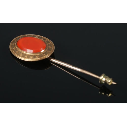 572 - A gold stick pin set with large orange stone. Gross weight 5.2g. Tests as high carat.