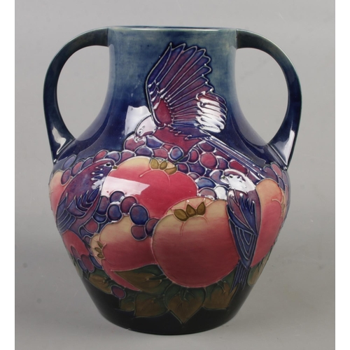 10 - A Moorcroft pottery twin handled vase decorated in the Finch And Berry pattern. Date cypher for 1993... 