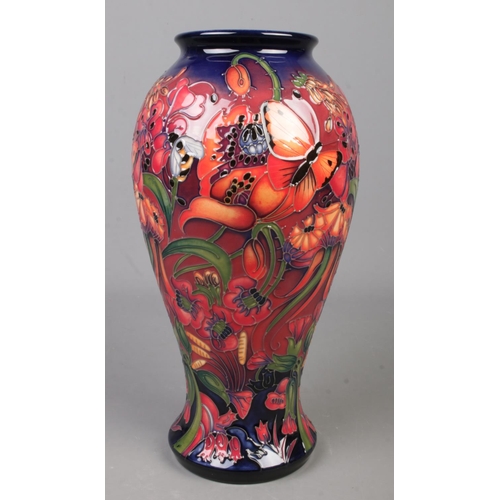 A Moorcroft pottery vase decorated in the flambe design with flowers, butterflies and bees by Emma Bossons. Date cypher for 2018. Height 31cm.