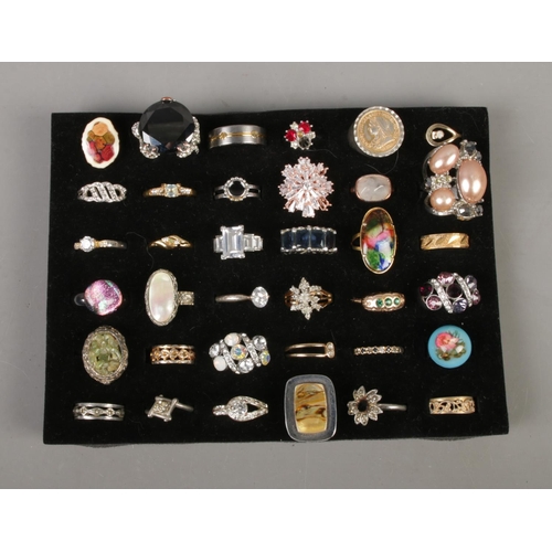 101 - A collection of 36 costume jewellery dress rings to include titanium, mother of pearl and floral exa... 