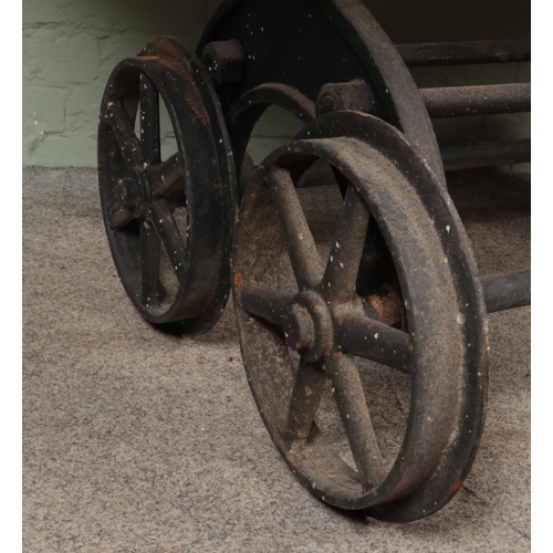 583 - A slated pitch pine table, raised on cast iron slate wagon base. Featuring six-spoke wheels and matc... 