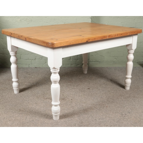 588 - A pine kitchen table with white painted turned supports.