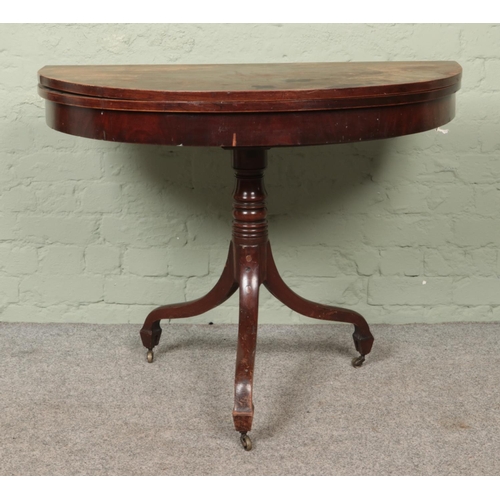 593 - A mahogany fold over card table of demi-lune form on turned pedestal base.

Hx73cm
Wx99cm
Dx50cm