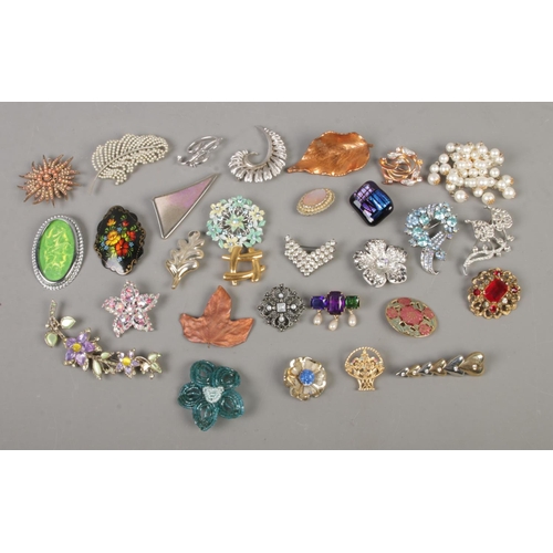 110 - A collection of costume jewellery brooches to include Monet, Movitex, leaf, and floral examples.