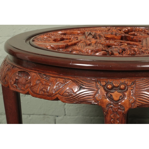 597 - Mahogany coloured carved Chinese design circular glass top coffee table with four smaller tables nes... 