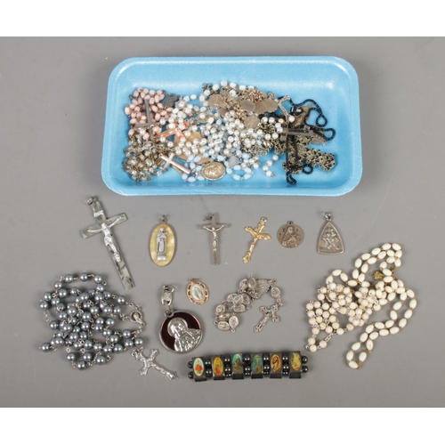 114 - A collection of religious jewellery to include rosaries, crucifixes, pendants, etc.