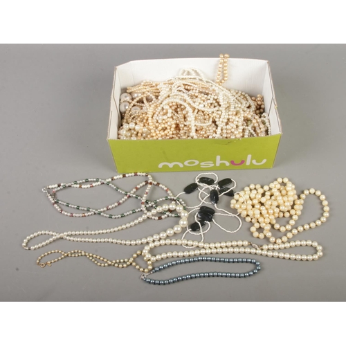 117 - A box of simulated pearls to include multi-strand and Lotus examples.