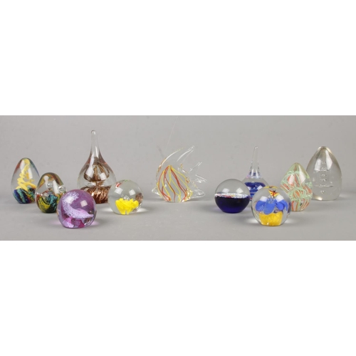 16 - Eleven glass paperweights, to include fish shaped, starfish, spiral and strand examples.