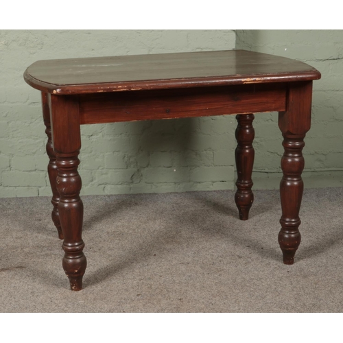 556 - A stained pine table with turned supports. Height: 77cm, Width: 106cm, Depth: 79cm.