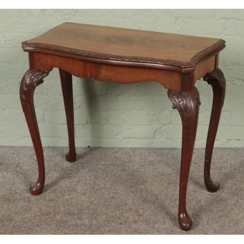 562 - A mahogany carved fold over card table with cabriole legs. Manufacturers label 