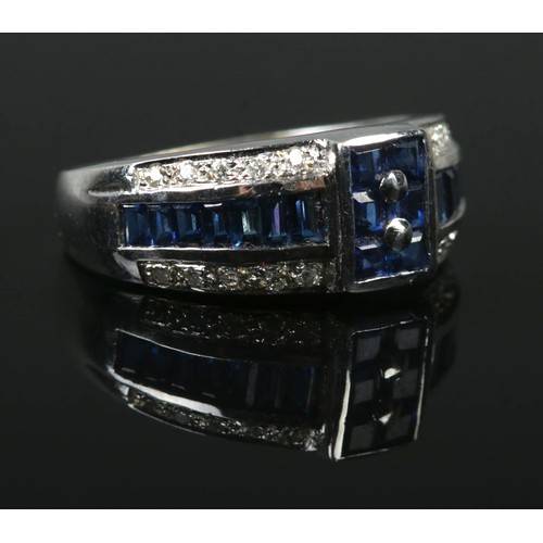 An 18ct White Gold, Diamond and Sapphire ring, with a row of baguette cut sapphires between two rows of illusion set diamonds. Size J. Total weight: 4.4g.