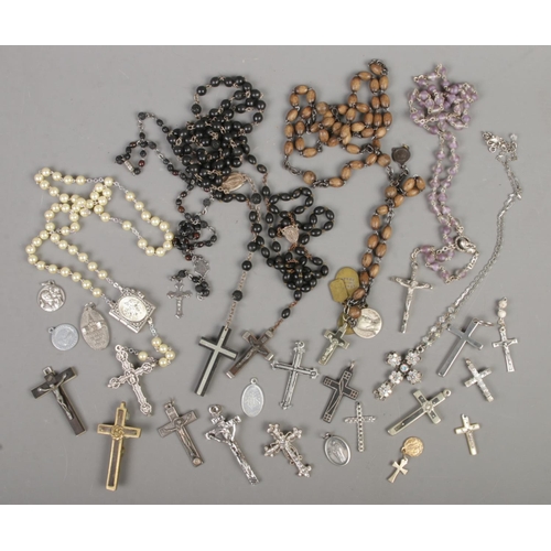 104 - A quantity of cross necklaces and religious themes pendants.