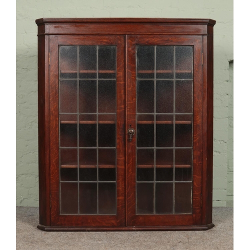 570 - A large Georgian style oak wall mounted corner cupboard, with twin lead glazed doors. Height: 127cm,... 