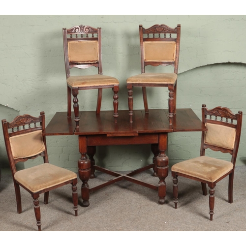 574 - A carved oak drawer leaf table along with four late Victorian dining chairs.